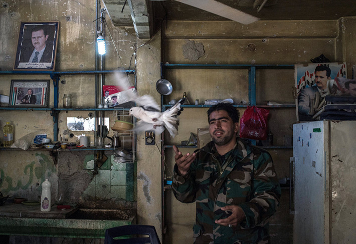 Một binh sỹ quân đội chính phủ Syria tại trạm kiểm soát ở quận đổ nát Al Hamidiyag, Homs. Ảnh Sputnik