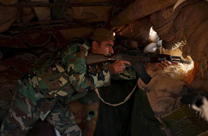 Một thành viên lực lượng Peshmerga nắm chắc vũ khí trong công sự.