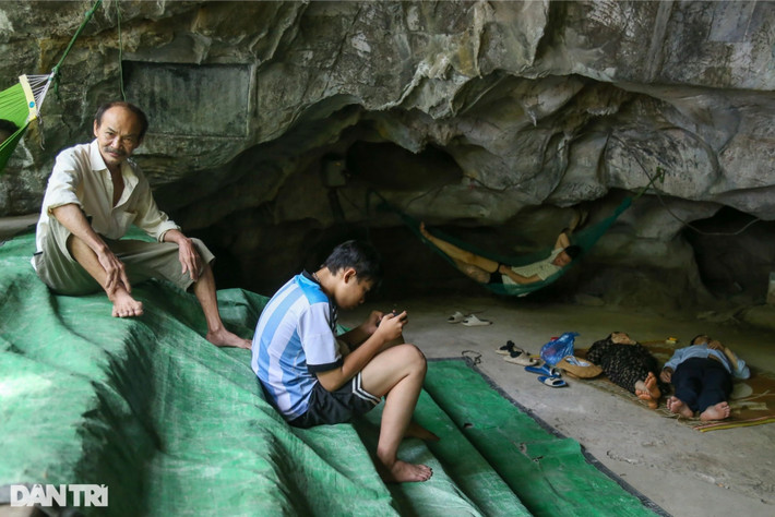 Sau giờ cơm trưa, hàng chục người mang theo nước đóng chai, chiếu, quạt giấy... vào hang động bên trong chùa Trầm để tránh nóng. Ảnh: Dân trí