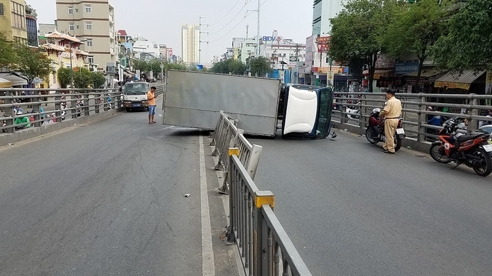 Hậu quả vụ tai nạn, 2 người bị thương nặng phải đưa bệnh viện cấp cứu, chiếc xe tải lật ngang chắn đường gây ùn tắc giao thông nghiệm trong. (Ảnh: Thảo Nguyện/Vietnamnet)