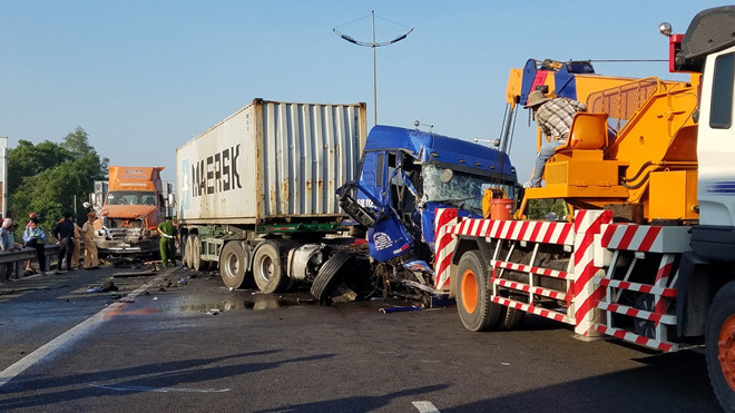 5. Xe container nát bét sau tai nạn: Vào 5h sáng 26/2, một chiếc xe đầu kéo container biển số tỉnh Bình Dương di chuyển trên cao tốc TP.HCM – Trung Lương, hướng Tiền Giang đi TP.HCM. Khi đến Km 29+100, xe này chết máy, dừng ở làn khẩn cấp. Sau đó, tài xế xe bị nạn nhờ một xe đầu kéo container khác mang biển số tỉnh Bình Dương đi ngang kéo ra khỏi cao tốc.Trong lúc tài xế đứng buộc xích hai phương tiện lại với nhau, một xe đầu kéo container mang biển số TP.HCM chạy cùng chiều phía sau lao đến tông vào xe đầu kéo gặp nạn. Hậu quả, hai tài xế tử vong tại chỗ, 3 xe ô tô hư hỏng nằm chắn hết 3 làn đường trên cao tốc TP.HCM - Trung Lương gây ùn tắc nghiêm trọng. (Ảnh: Zing)
