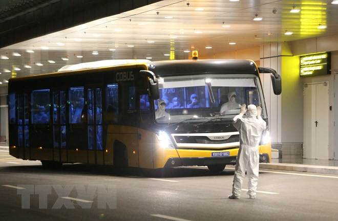 Các công dân được chở bằng xe buýt từ máy bay vào khu vực khử trùng và làm thủ tục nhập cảnh. (Ảnh: TTXVN)