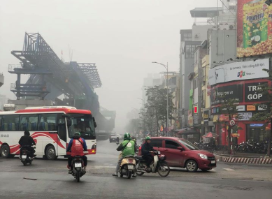Tại ngã tư Tam Trinh - Minh Khai, các tòa nhà cao tầng dọc 2 bên đường biến mất trong làn sương mù.