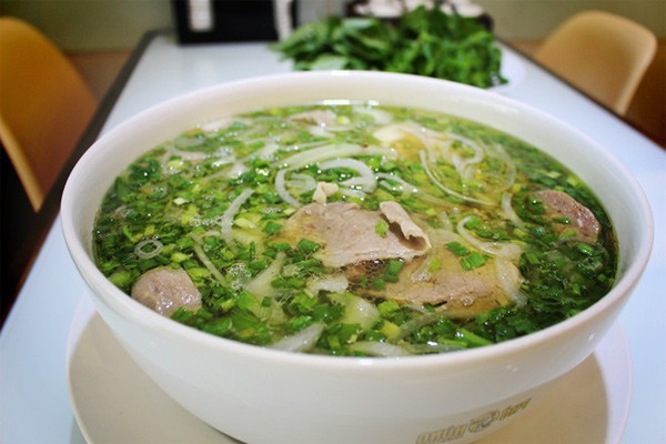 Phở có vị ngọt, béo nhưng không kém phần đậm đà của nước hầm xương, vị thanh mát của sợi phở, vị nồng nàn của lát thịt bò xắt mỏng, thơm cay của rau thơm. Ảnh: An Huỳnh.