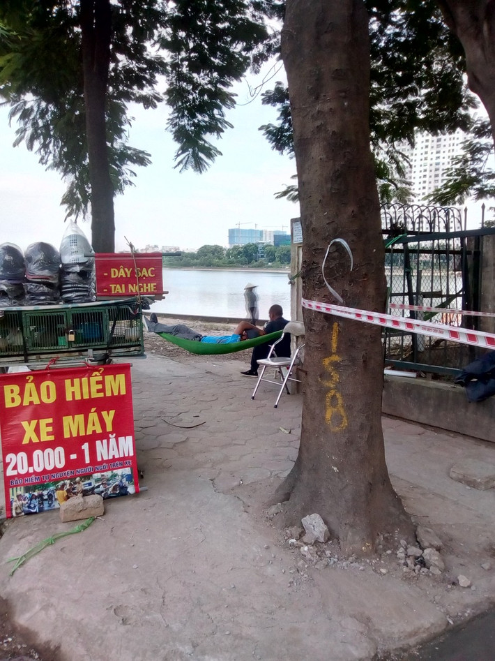 Với người bán hàng rong, quán cóc ven giường khi tranh thủ vắng khách họ thường có giấc ngủ trưa luôn tại chỗ, hoặc đem theo võng ngả lưng dưới các tán cây rộng. Ảnh: CTV