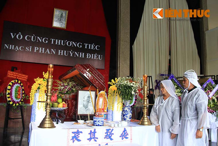 Ông Phan Hồng Hà (con trai nhạc sĩ Phan Huỳnh Điểu) và người con gái nuôi Nguyễn Ánh Tuyết đứng ngắm nhìn di ảnh ba mình tại lễ tang.