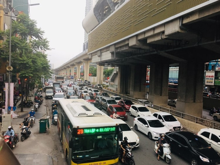 Ô tô chiếm hết lòng đường khiến xe máy phải leo lên vỉa hè.
