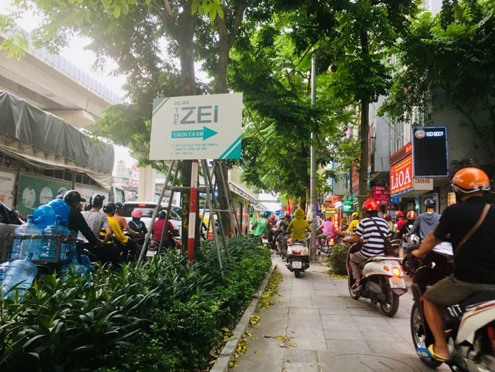 Hàng loạt xe máy nối đuôi nhau đi trên vỉa hè.