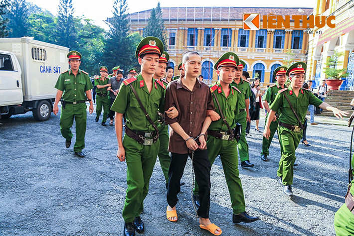 Bị cáo Nguyễn Hải Dương - kẻ chủ mưu vụ thảm sát được cảnh sát dẫn giải vào toà. Ảnh: Hoàng Thiên Dũng