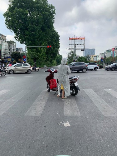 Tại một ngã tư tại Hà Nội, cũng là một người phụ nữ trong bộ dạng "kín mít" từ đầu tới chân quay ngang xe, dựng chân chống giữa đường để làm việc riêng cũng khiến không ít người phải lên tiếng. Ảnh: Tổng hợp