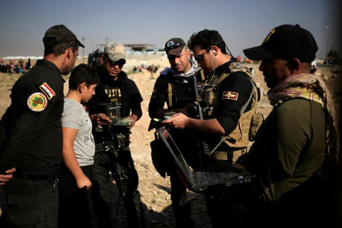 Các thành viên đặc nhiệm Iraq đang tra soát giấy tờ nhân thân của một người đàn ông ở trạm kiểm soát ở Kokjali. Ảnh Reuters