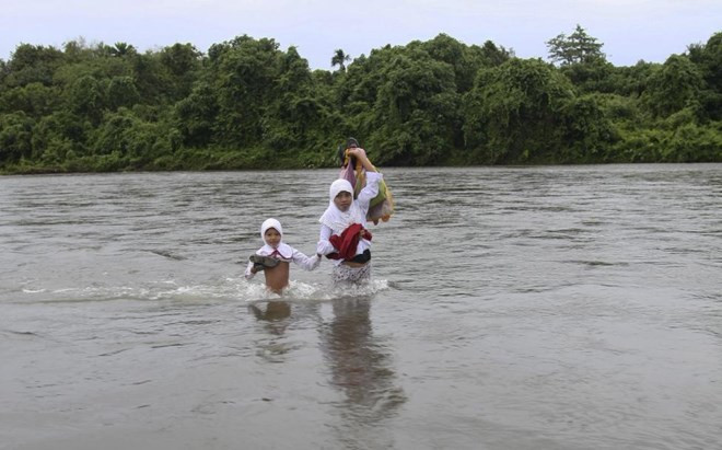 Lội qua sông sâu để đến trường ở làng Nagari Koto Nan Tigo, tỉnh Tây Sumatra, Indonesia.