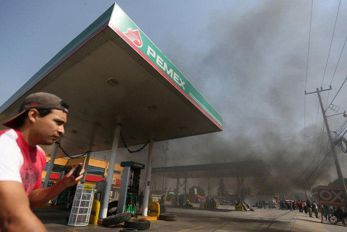 Đám người biểu tình đốt lốp ở phía ngoài trạm xăng ở San Miguel Totolcingo. Ảnh Reuters