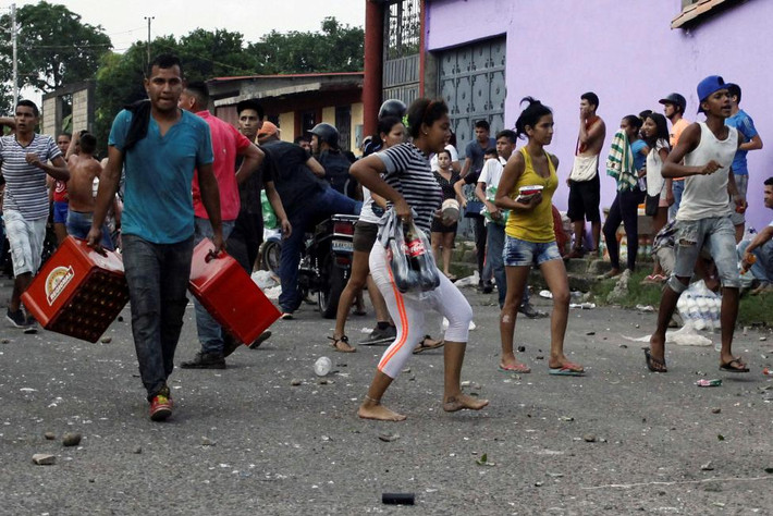 Dân thường Venezuela xách đồ mới lấy được từ một cửa hàng. Ảnh Reuters