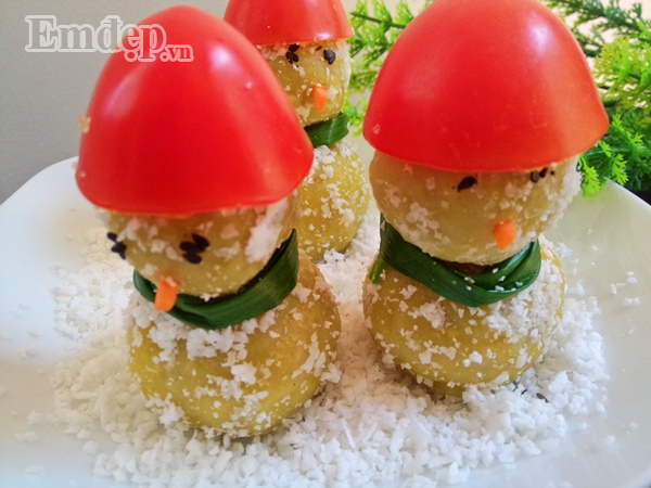 Bước 6: Nặn bột thành hai loại viên tròn to và nhỏ rồi cho vào nồi hấp chín. Bước 7: Lăn viên bánh đã hấp qua đĩa vụn dừa Bước 8: Tạo hình người: đặt viên bánh to xuống dưới làm mình, lấy que xiên xiên vào giữa rồi xiên viên bánh bé lên trên làm đầu. Dùng hạt vừng đen làm mắt, dùng một mẩu cà rốt làm mũi, lấy hành đã trần làm khăn quàng cổ, lấy miếng cà chua làm mũ.