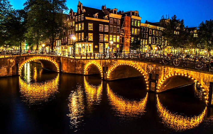 1.281: Đó là tất cả số cầu ở Amsterdam, trong đó 80 cầu nằm trong trung tâm thành phố. Magere Brug - còn được gọi là cầu Skinny - là cây cầu nổi tiếng nhất. Ngoài ra, nơi kênh đào Reguliersgracht và Herengracht giao nhau chính là cầu Bridge of 15 Bridges. Nếu tìm được vị trí lý tưởng, đặc biệt vào ban đêm, bạn có thể nhìn thấy những nhịp cầu có 15 mái vòm được chiếu sáng lung linh. Ảnh: Traveltipy.