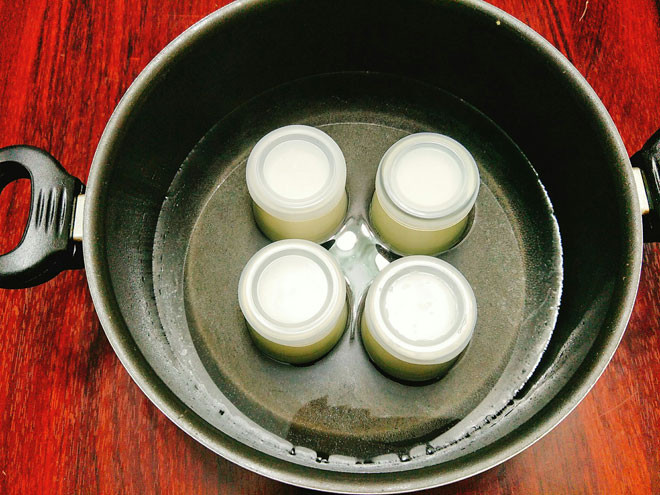 Bước 4: Cho nước ấm vào nồi hoặc thùng xốp sau đó đặt các hũ sữa chua vào, lượng nước ngập 1/2 hũ sữa chua là được.