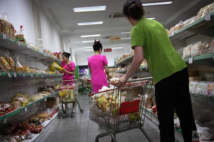 Nhân viên cửa hàng Potonggang bổ sung hàng hóa lên các kệ hàng, phần lớn hàng hóa này được sản xuất trong nước và nhập khẩu từ Trung Quốc. (Ảnh: AP)