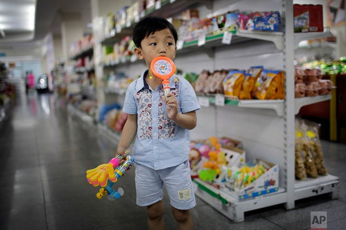 Cậu bé đứng trong cửa hàng Potonggang, Bình Nhưỡng. (Ảnh: AP)
