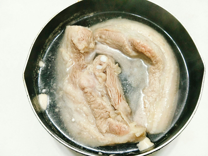 Hướng dẫn cách làm: Thịt ba chỉ bạn cạo sạch phần bì, rửa lại thật sạch. Đổ nước vào nồi đun sôi rồi bạn cho một chút muối vào nồi, tiếp theo bạn cho thịt ba chỉ vào luộc sơ qua khoảng 2 phút xong vớt ra đĩa để cho nguội bớt.