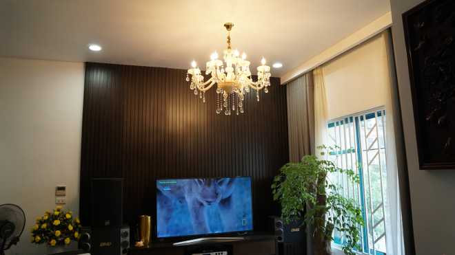 Ngoài ánh sáng tự nhiên từ cửa sổ, phòng khách còn được trang trí bởi chùm đèn pha lê tạo cảm giác sang trọng, ấm cúng.