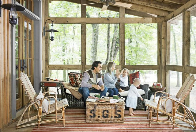 Giữ căn gác mái ấm áp Chủ căn nhà ở Tennesse tha hồ ngắm lá cây trong một căn phòng kính với bộ bàn ghế mây, ghế ngồi bãi biển, và chiếc bàn thùng mây ngồi nhâm nhi cà phê.