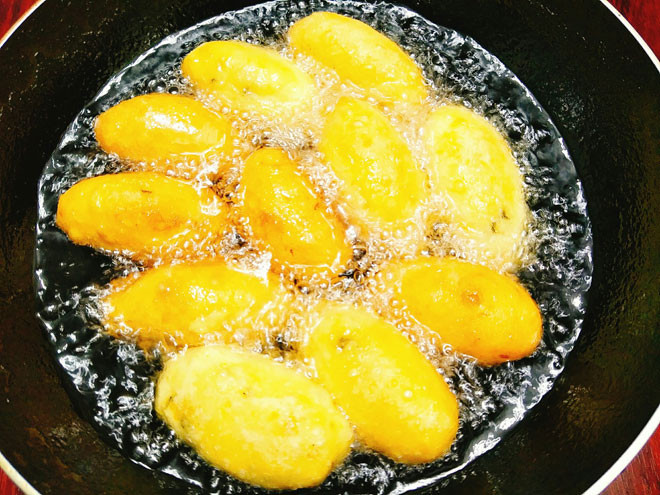 Bước 8: Đặt chảo lên bếp cho nhiều dầu vào đun cho nóng dầu, tiếp theo bạn thả từng chiếc bánh vào chiên, khi bánh sắp ngả màu vàng thì lật bánh chiên tiếp tới khi bánh chín vàng đều thì vớt ra đĩa có lót sẵn giấy thấm dầu.