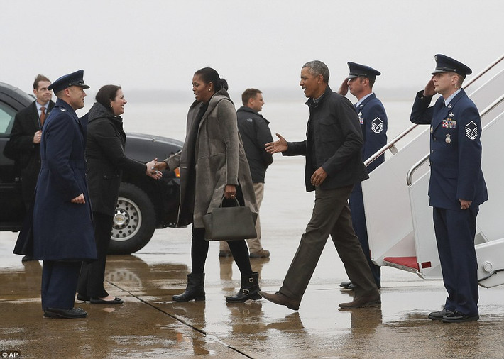 Ông Obama và Đệ nhất phu nhân Michelle bắt tay chào các trợ tá đang đứng đón họ ở sân bay. Ảnh Daily Mail