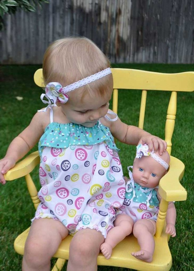 Hình ảnh giống y như đúc giữa em bé và con búp bê. Ngay cả quần áo và nơ đeo đầu cũng không có bất cứ điểm khác biệt nào. Ảnh: Brightside.