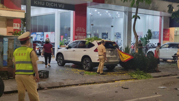 Chiếc xe ô tô 4 chỗ bất ngờ lao lên vỉa hè đâm liên tiếp vào các gốc cây cùng 2 xe ô tô khác đang đỗ trên vỉa hè.