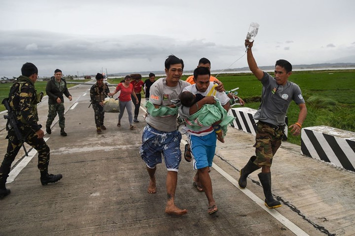 Các binh sĩ Philippines hỗ trợ đưa một em bé tới cơ sở y tế để chăm sóc. Ảnh: AFP/Getty.