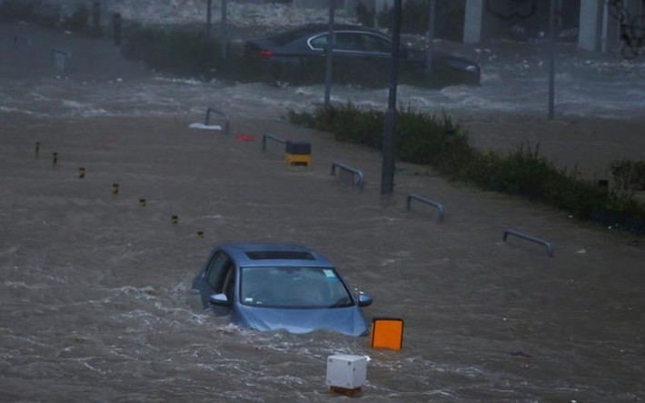Xe ô tô “bơi” trong biển nước trên đường phố ở Hong Kong. Ảnh: Reuters.