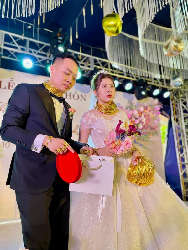 Trên MXH mới đây đang chia sẻ rầm rộ hình ảnh cặp đôi cô dâu chú rể được cho vòng vàng nhiều đến mức đeo kín người, cầm không xuể tay khiến cộng đồng mạng "dậy sóng".