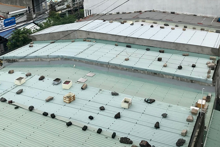 Trên các mái nhà xuất hiện những bao tải cát, gạch, đá, sỏi... hoặc những vật nặng để chặn cho mái tôn khỏi bay.