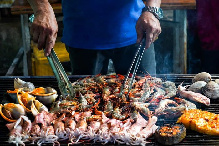 Một điểm cộng không thể bỏ qua khi đến Hà My là ẩm thực hải sản tươi ngon, được chế biến ngay tại chỗ bởi người dân địa phương. Từ cá nướng mọi, sò điệp nướng mỡ hành đến mực hấp gừng, tất cả đều giữ trọn hương vị biển cả. Giá cả ở đây cũng hợp lý, phù hợp với mọi đối tượng du khách. Ảnh Mytour