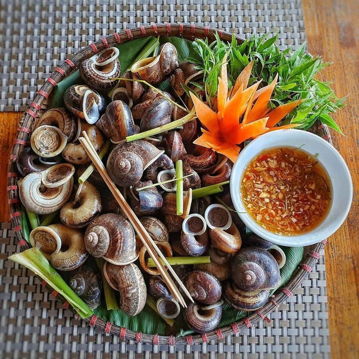 Ốc xu là loại ốc sống trong các khe đá trên núi Bà Đen, chỉ xuất hiện vào mùa mưa. Với thịt ngọt và giòn đặc trưng, ốc xu thường được chế biến thành các món hấp, xào me hoặc nướng mỡ hành. Món ăn này không chỉ ngon mà còn mang đậm hương vị núi rừng của Tây Ninh. Nếu có dịp ghé thăm núi Bà Đen, du khách đừng quên thưởng thức món ốc xu độc đáo này. Ảnh MIA