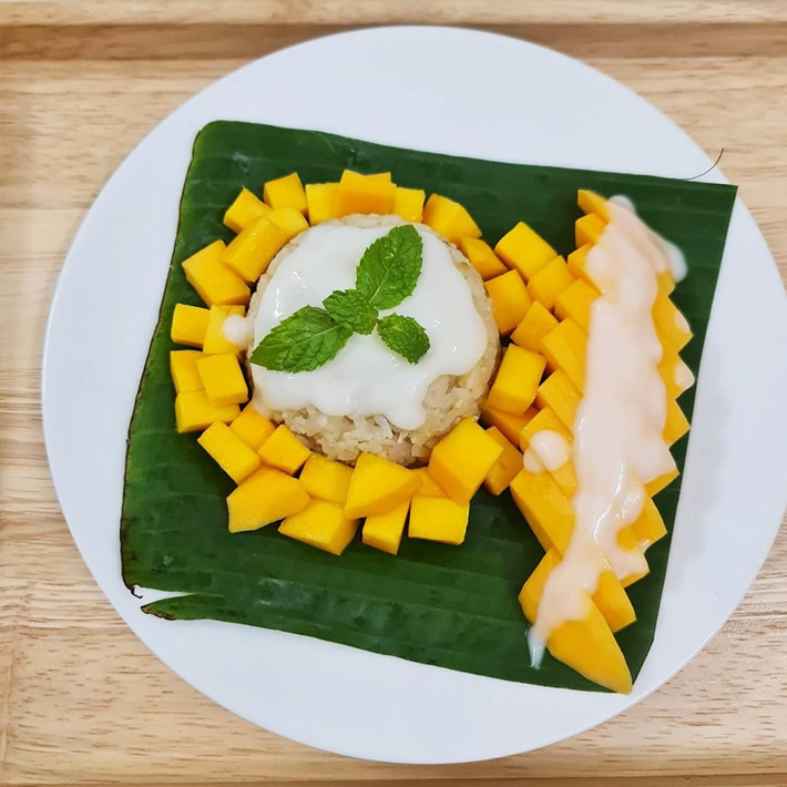 Ở Thái Lan, mùa hè thường rất nóng bức và oi ả, vì vậy xôi xoài chính là món ăn lý tưởng để làm dịu đi cái nóng. Với sự tươi mát của xoài cùng độ dẻo và béo ngậy của xôi, món tráng miệng này như một thức quà hoàn hảo để giải nhiệt trong những ngày hè oi ả. Mỗi miếng xôi xoài mang đến cảm giác mát lạnh, nhẹ nhàng và đầy đủ dưỡng chất, giúp bạn cảm thấy tươi mới và sảng khoái. Ảnh Holivn Travel