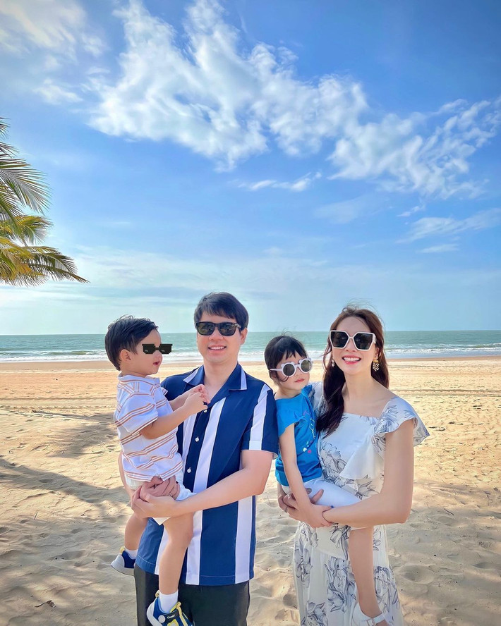 Bà mẹ hai con chọn mẫu váy trắng họa tiết tông xanh, tôn làn da trắng trong một lần khác đi biển cùng cả nhà.