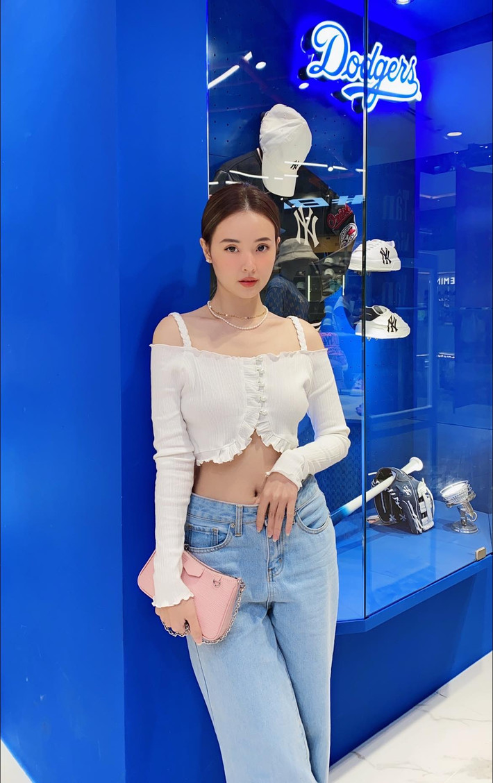 Khác hẳn váy nàng thơ, bay bổng như mọi lần, Midu chọn chiếc áo croptop tông trắng và quần jean ống suông. Việc diện áo ngắn đã vô tình để lộ vòng eo con kiến của Midu.
