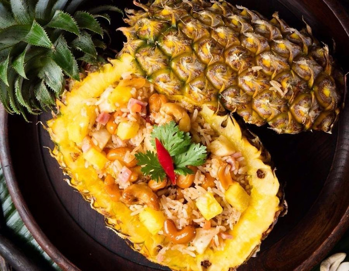 Thay vì cơm chiên truyền thống, bạn có thể thử món cơm chiên hải sản trái thơm. Cơm chiên với tôm, mực, rau củ và trái thơm khoét rỗng tạo nên một món ăn vừa lạ miệng, vừa bắt mắt. Món cơm này không chỉ bổ dưỡng mà còn mang đến sự mới mẻ cho bữa cơm gia đình trong dịp lễ. Ảnh Internet