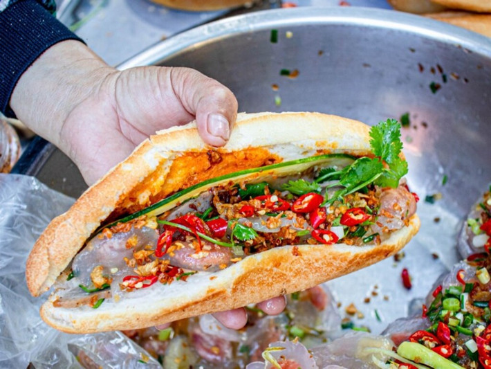 Bánh bột lọc không còn xa lạ gì với du khách đến miền Trung, nhưng ở Quảng Bình có món ăn khá độc đáo là bánh mì kẹp bột lọc. Những viên bột lọc nhân tôm và nhân đậu xanh được chủ quán nhanh tay bỏ vào trong bánh mì còn nóng, chan thêm nước sốt cay. Ảnh Internet