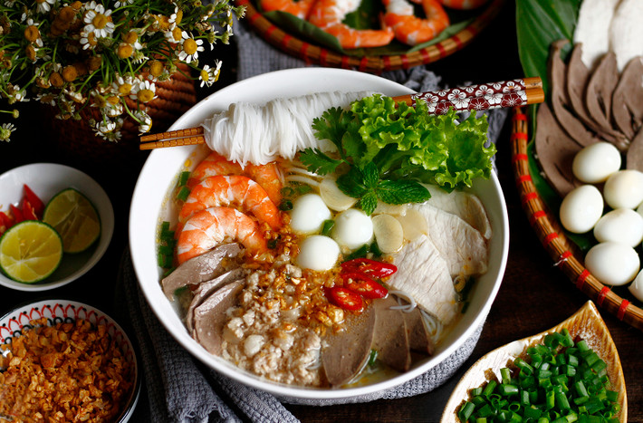 Buổi sáng ở TP HCM sẽ không trọn vẹn nếu thiếu một tô hủ tiếu nóng hổi. Hủ tiếu Nam Vang là loại phổ biến nhất, với nước dùng trong, ngọt thanh từ xương hầm, ăn cùng thịt heo, gan, trứng cút và tôm tươi. Ngoài ra còn có hủ tiếu sa tế cay nồng, hủ tiếu bò kho đậm đà, hay hủ tiếu khô trộn sốt độc đáo. Đây là món ăn dung dị, quen thuộc nhưng chứa đựng cả tinh thần ẩm thực miền Nam. Ảnh Cookpad
