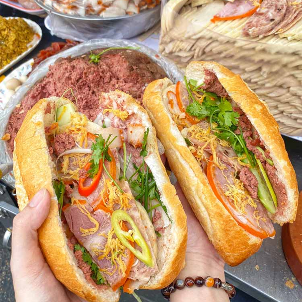 Điểm khởi đầu lý tưởng cho hành trình khám phá ẩm thực chính là bánh mì – món ăn đã trở thành biểu tượng không thể thiếu của Việt Nam trên bản đồ ẩm thực thế giới. Bánh mì Sài Gòn có thể đơn giản chỉ là pate, chả, hoặc phong phú hơn với thịt nướng, xíu mại, trứng muối… Nhưng điều làm nên sự khác biệt là nước sốt béo ngậy, đậm đà, cùng lớp vỏ bánh giòn rụm bên ngoài, mềm mại bên trong. Ảnh amthucviet