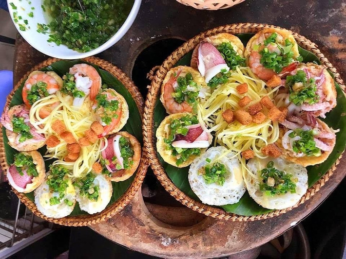 Khi no nê với hải sản tươi rói, đừng quên thưởng thức món bánh căn hải sản dân dã – một nét chấm phá mộc mạc nhưng quyến rũ. Những chiếc bánh nhỏ xinh, vàng ruộm được đổ trong khuôn đất, phủ lên nào tôm, nào mực, nào trứng, ăn kèm nước chấm đậm đà và rau sống tươi xanh, đơn giản thôi mà khiến người ta cứ xuýt xoa mãi không thôi.