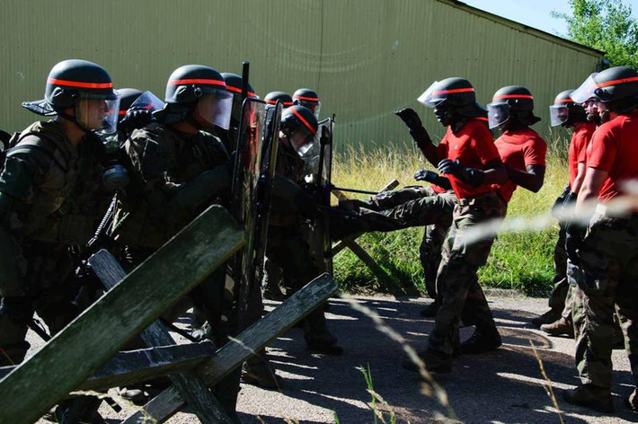 Sử dụng lá chắn và đội hình dàn hàng ngang để phòng thủ trước đám đông quá khích. Nguồn ảnh: Sina.
