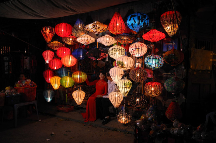 Đôi bạn trẻ chụp ảnh bên đền lồng treo bên ngoài một cửa hàng bán đồ lưu niệm ở phổ cổ Hội An, tỉnh Quảng Nam. Ảnh USN