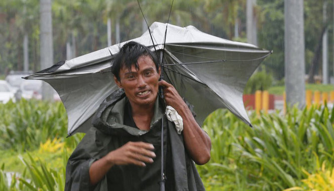 Một người dân ở Philippines giữ chặt chiếc ô bị gió tạt tung.