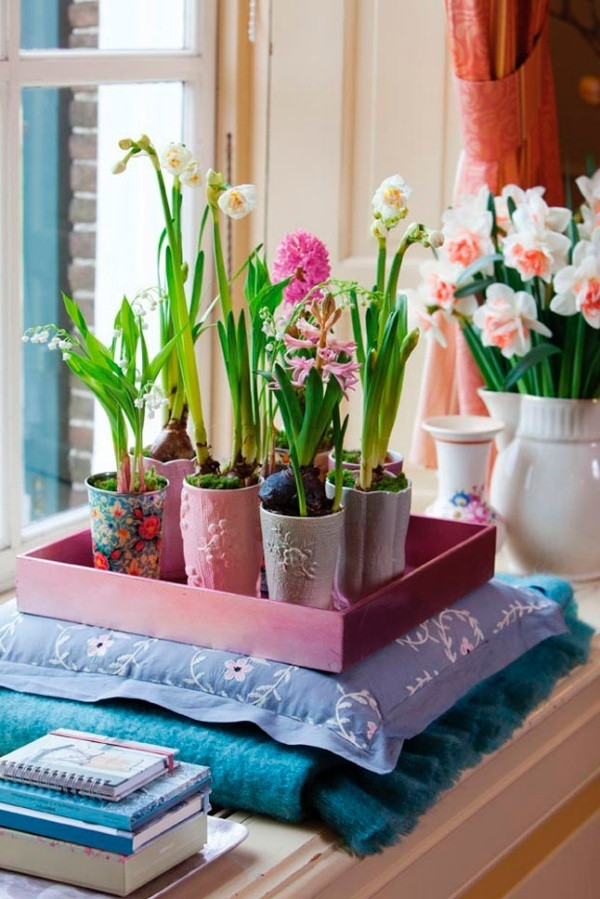 Một góc nhỏ cạnh cửa sổ được trồng các loài hoa từ củ. Mỗi củ hoa là một chiếc bình với họa tiết và màu sắc khác nhau. Góc nhỏ tươi tắn sắc màu thiên nhiên cho ngôi nhà bừng sáng sắc màu mùa xuân.
