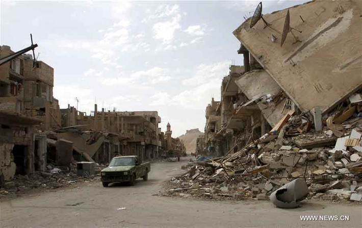 Xe bán tải của quân chính phủ bon bon chạy qua con đường giữa đống đổ nát ở Palmyra, miền trung Syria hôm 11/4/2016.