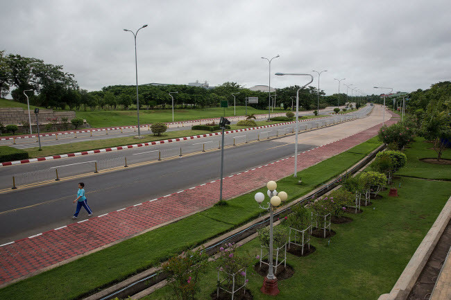 Một người phụ nữ đi trên đường không một bóng xe cộ tại thành phố Naypyidaw.